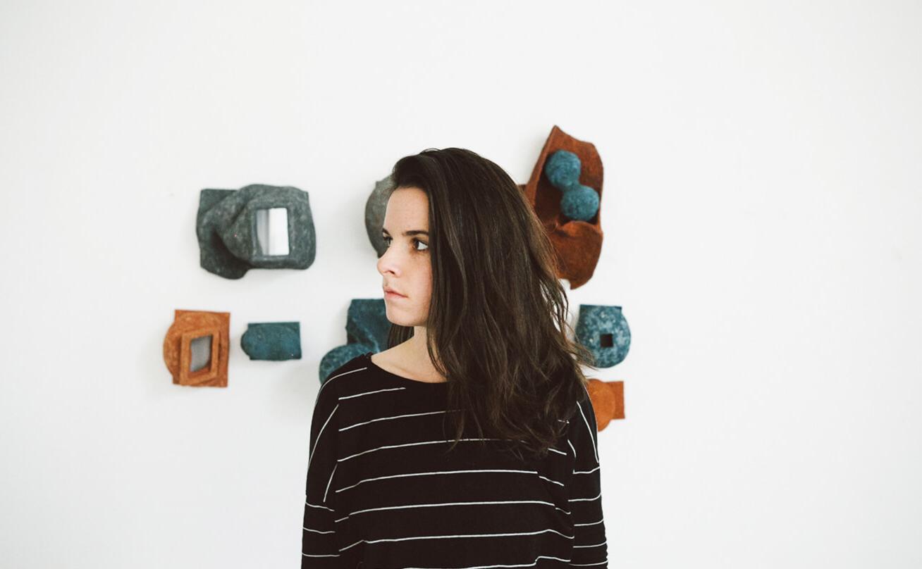 Woman standing in front of sculpture installation