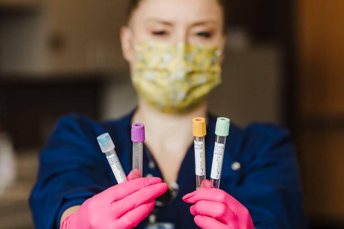 Phlebotomist holding blood draw vials